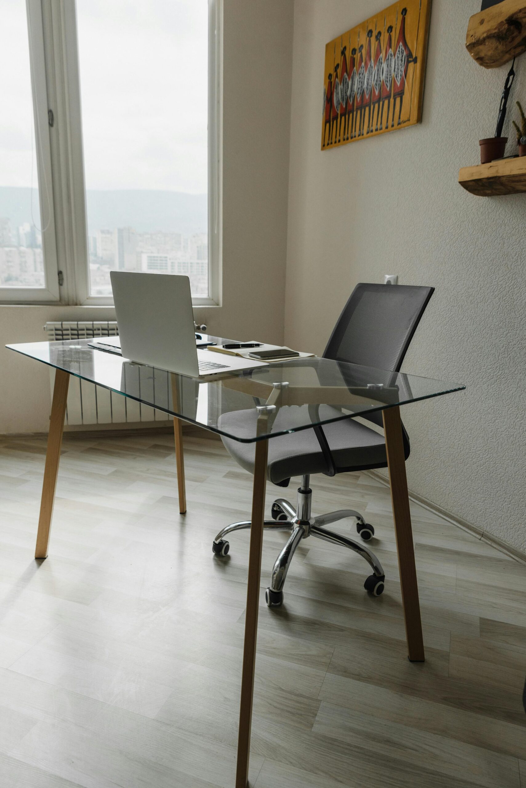 Minimalist workspace with a glass desk and laptop, symbolizing the importance of an organized environment for crafting SEO-optimized blog posts