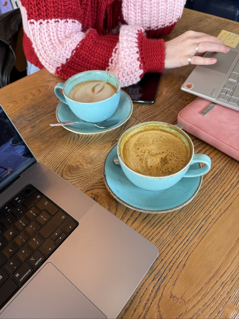 A turmeric latte and an oat milk latte next to 2 laptops at Cult of Coffee Aberdeen